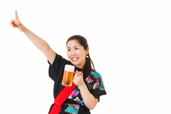 ビールを片手に指を指す女性。
