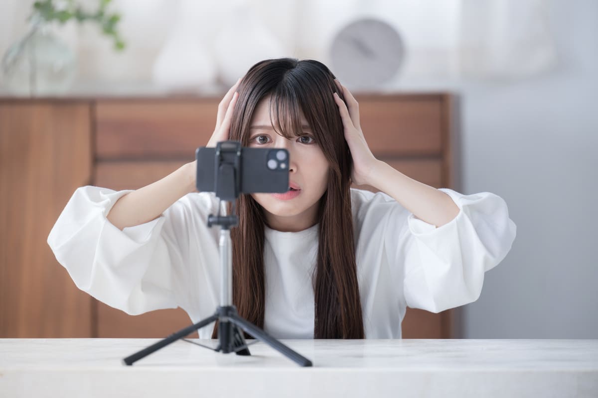 スマホ　撮影　悩む女性