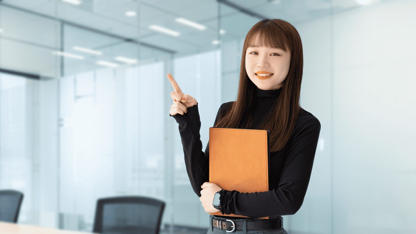 人差し指を立てて案内する女性
