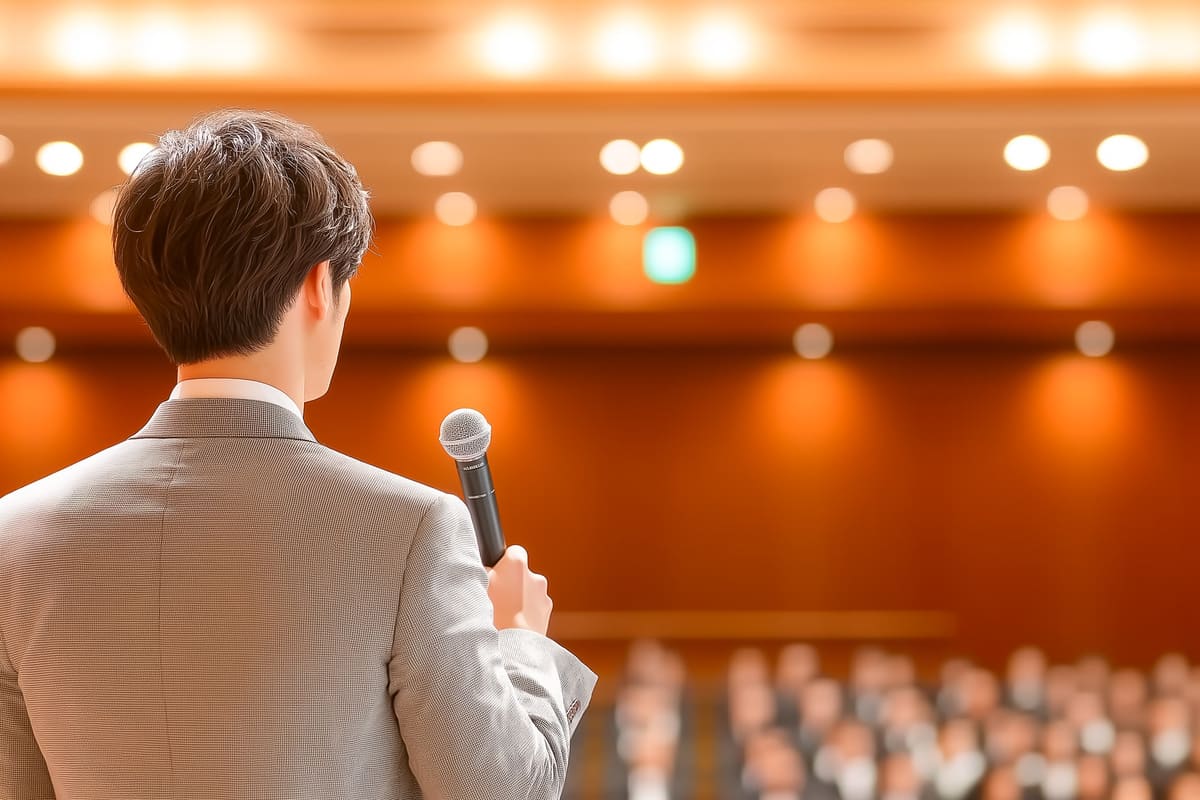 大勢の聴衆の前で講演をするビジネスマン