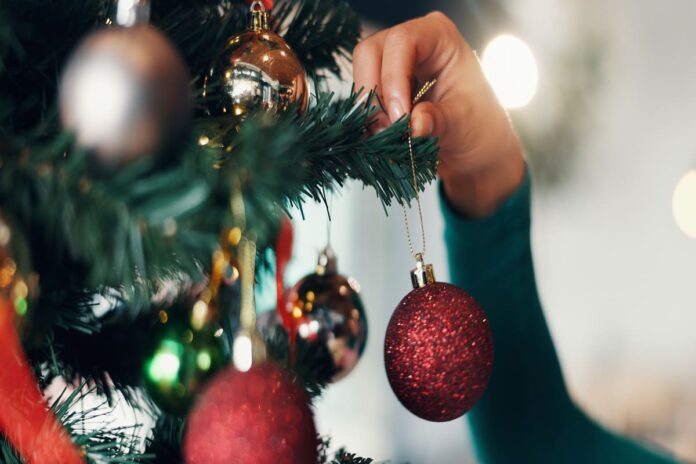 クリスマスの飾りつけをする手