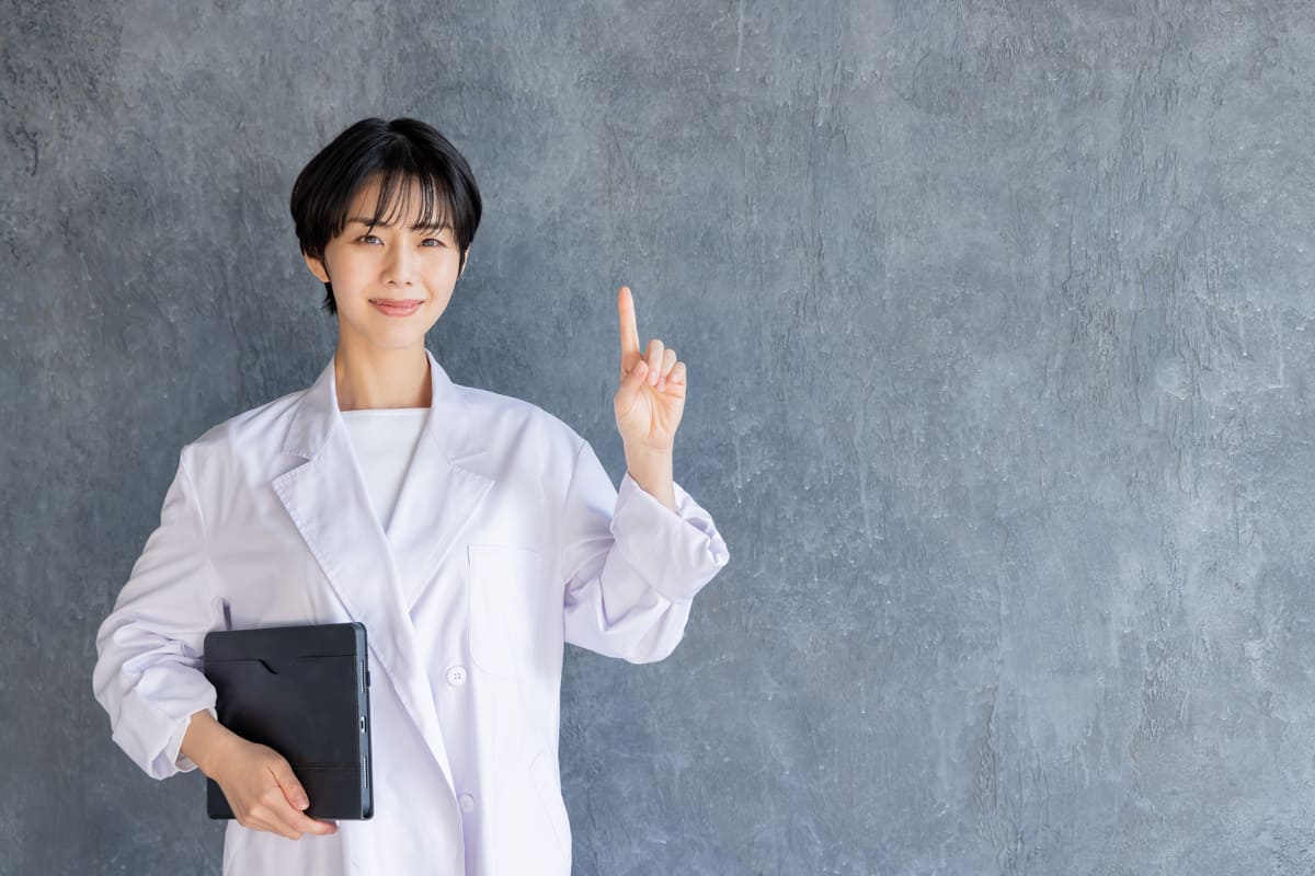 資料を持ち、人差し指を立てる女性専門家