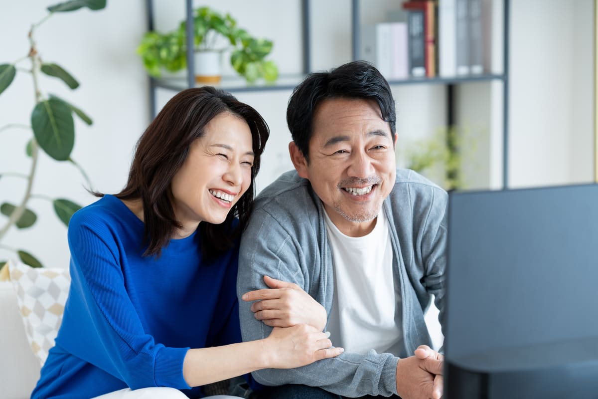 TVの前でほほ笑む夫婦