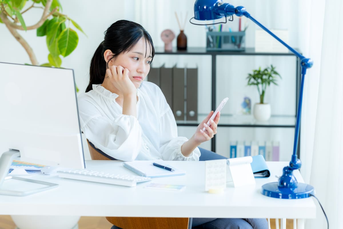 デスクで悩んでいる様子の女性