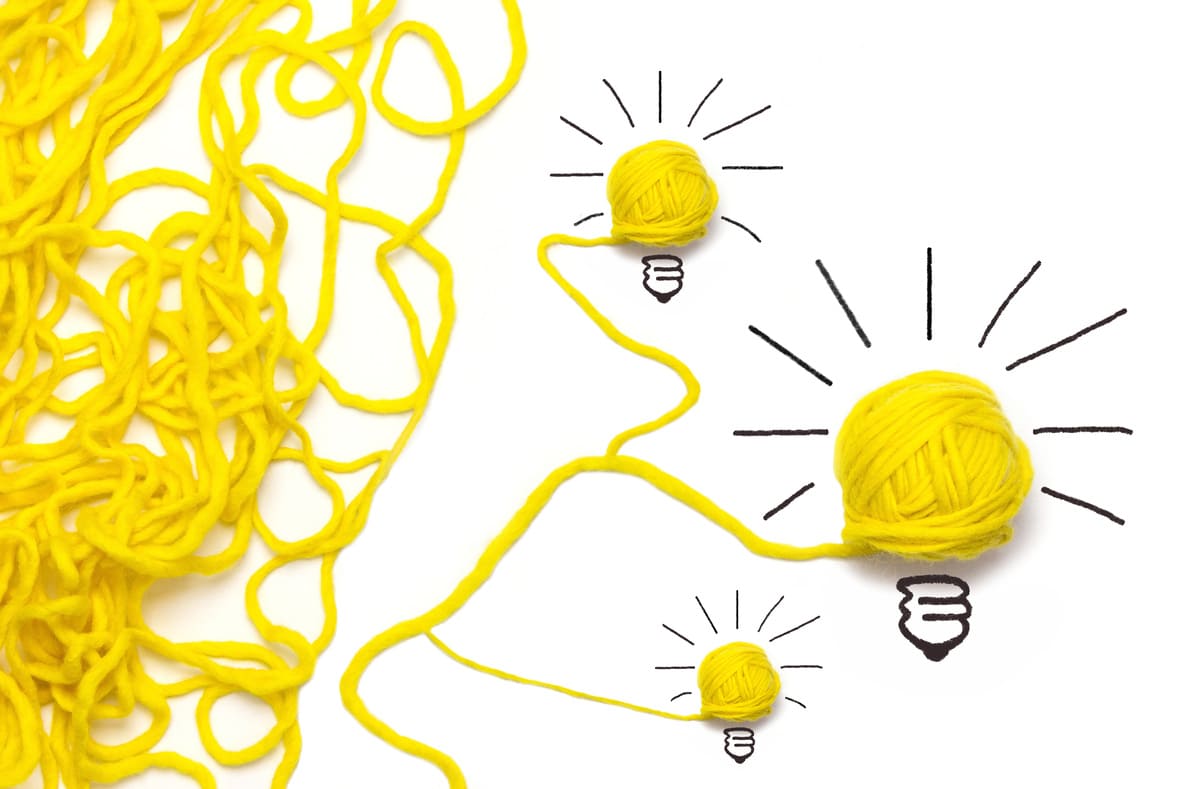 こんがらがった毛糸がほどけていく様子とひらめきマーク