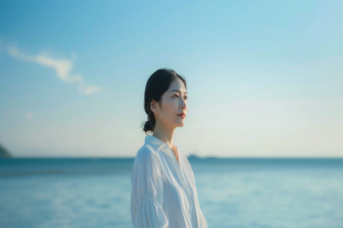 海の前に立つ白服の女性