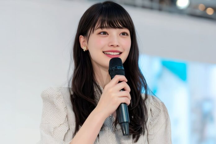 マイクを持って話す若い女性