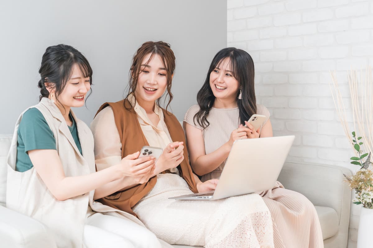スマホとPCを持つ女性3人
