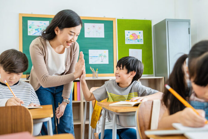 先生とタッチする小学生