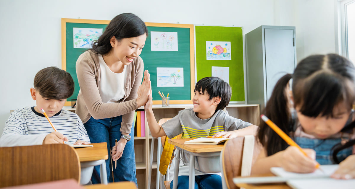 先生とタッチする小学生
