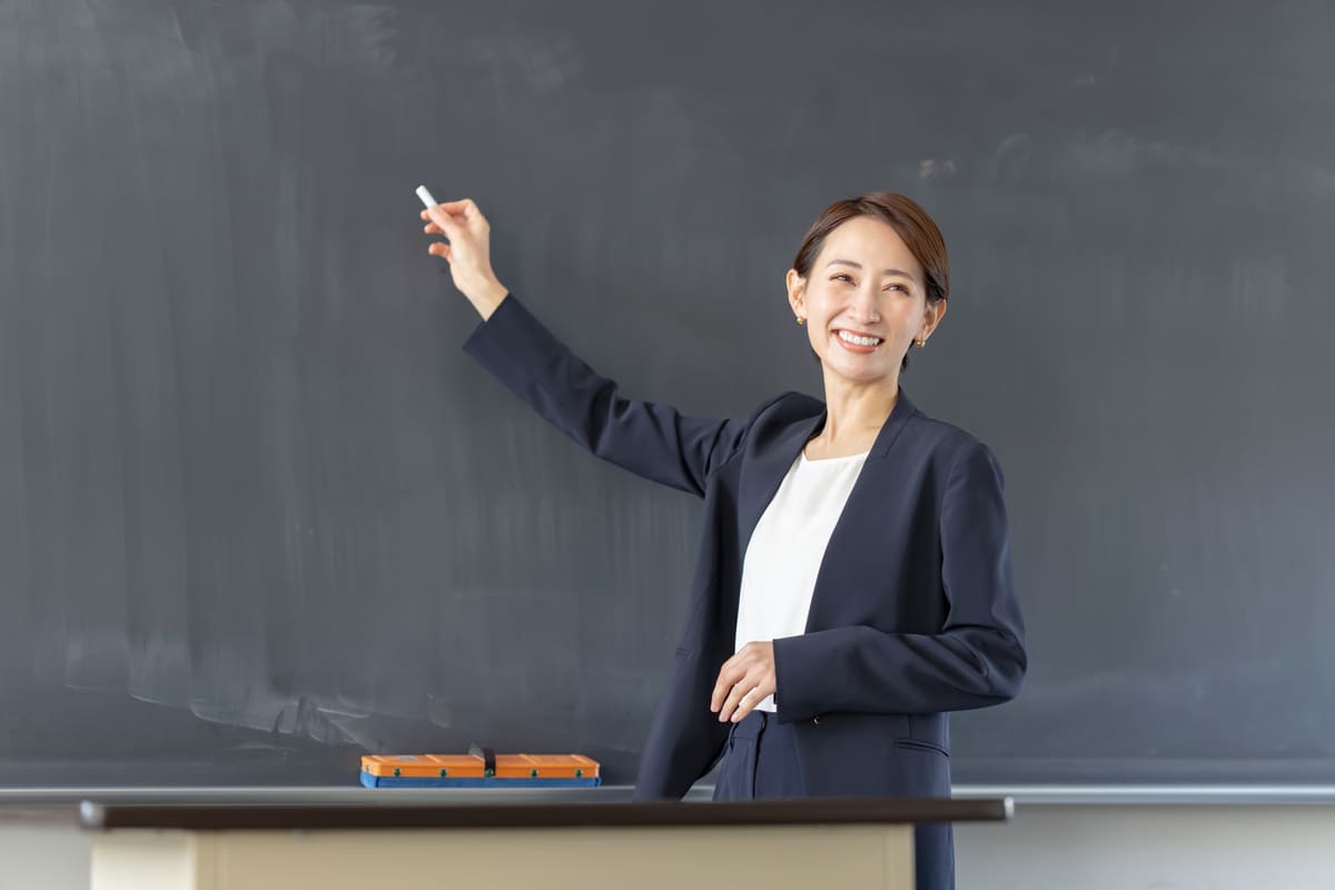 黒板の前の女性教師