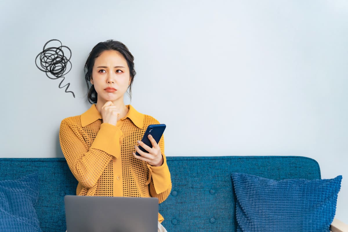 スマホを見ながら困る女性