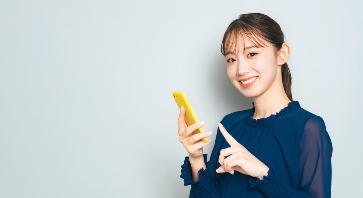笑顔でスマホを使う女性